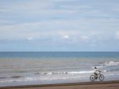 Un enfant fait du vélo sur une plage.